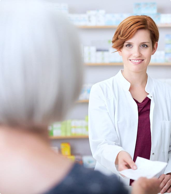 pharmacist giving prescription to customer