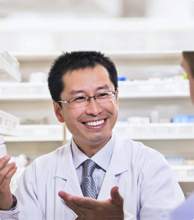 smiling pharmacist showing prescription medication to a customer