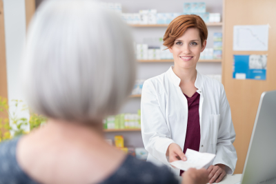 pharmacist giving prescription to customer